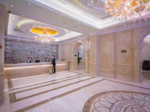 um homem numa sala grande com um lustre em Vienna International Hotel Yichang Gezhouba Sanxia Culture Tiandi em Yichang