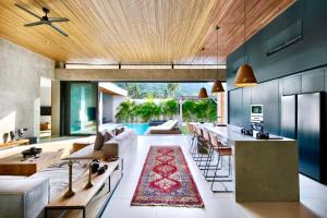 an open kitchen and living room with a couch and a table at Kabila Villas in Kuta Lombok
