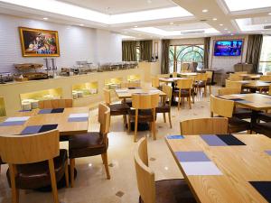 une salle à manger avec des tables et des chaises en bois dans l'établissement Vienna International Hotel Nanjing Dongshan Headquarters, à Yangzhou