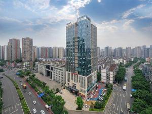 Kyriad Marvelous Hotel Chongqing North Railway Station في تشونغتشينغ: مبنى طويل وكبير في مدينة بها زحمة