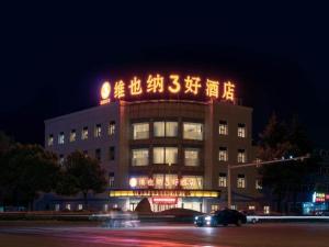 un bâtiment avec un écriture en haut de celui-ci la nuit dans l'établissement Vienna SanHao Hotel Danyang Houxiang, à Matunlijia