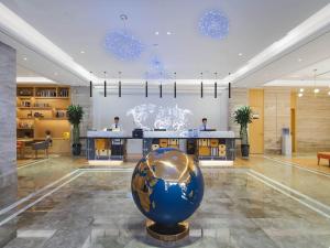 a lobby with a large blue ball in the middle at Kyriad Marvelous Hotel Bozhou Wanda Plaza in Bozhou
