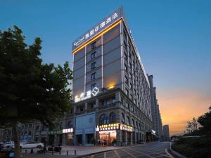 wysoki budynek z znakiem na boku w obiekcie Kyriad Marvelous Hotel Bozhou Wanda Plaza w mieście Bozhou