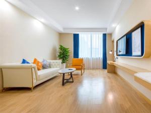 a living room with a couch and a table at Kyriad Xi'an High-Tech Sunshine Paradise in Chang'an