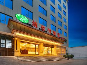 un bâtiment avec un panneau à l'avant dans l'établissement Vienna hotel Hunan Shaoyang Longhui Bus Station, à Longhui