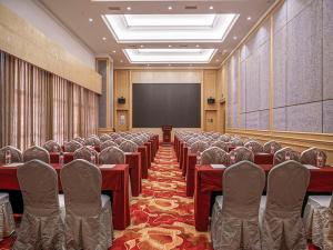 a conference room with tables and chairs and a screen at Vienna International Hotel Chongqing Ranjiaba in Chongqing