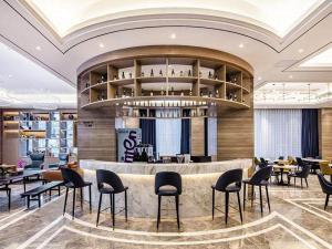 un restaurante con barra con sillas y mesas en Kyriad Marvelous Hotel Haifeng, en Haifeng