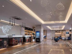a large lobby with a store with a world on the wall at Kyriad Marvelous Hotel Huizhou South Station Danshui YI Center in Huizhou