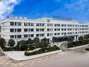 a large white building with a sign on it at Kyriad Marvelous Hotel Jingxian in Jing