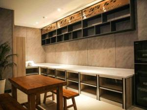 a room with a table and a counter with shelves at Magnolia Business Hotel Yangzhou Wanda Plaza Shunda Road in Yangzhou