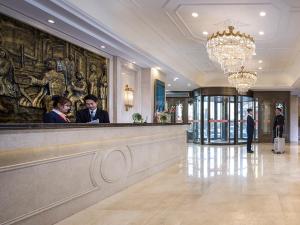 2 personnes debout au bar dans le hall de l'hôtel dans l'établissement Vienna Classic Hotel Manzhouli Zhongsu Street, à Manzhouli