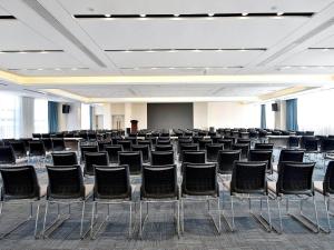 an empty room with chairs and a projection screen at Kyriad Marvelous Hotel NanChang Xiang Lake Jinsha Avenue in Nanchang