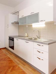 a kitchen with white cabinets and a sink at Apartman Žuvela in Vela Luka