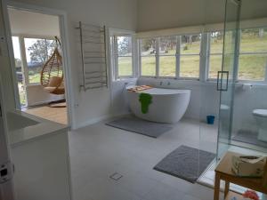 a bathroom with a tub and a glass shower at Galah Cottage Stanthorpe in Dalveen