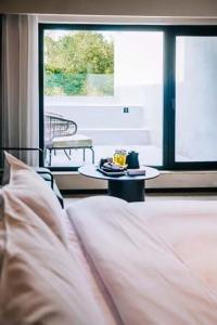 um quarto com uma cama, uma mesa e uma janela em Zhi Resort Beijing em Pequim