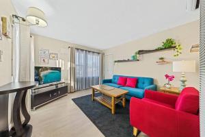sala de estar con sofá azul y sillas rojas en Cozy and Bright Centrally Located NEW 2BR Property!, en Inglewood