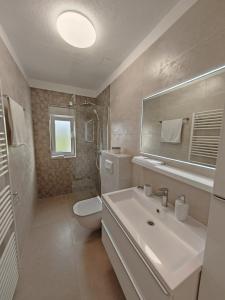 y baño con lavabo, aseo y espejo. en Luxury Villa Nikoma with heated pool and whirlpool, en Dicmo