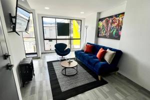 sala de estar con sofá azul y silla en Luxury Corferias-USA Embassy & Airport Condominium, en Bogotá