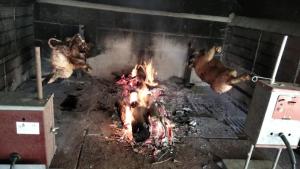 a grill with chickens and a fire in it at Sardinia Ovest 2 in Putzu Idu