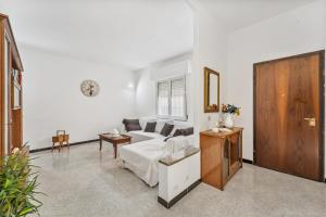 uma sala de estar com um sofá branco e uma porta de madeira em Garden Holiday Inn em Elmas