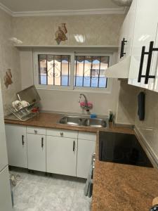 a kitchen with white cabinets and a sink at Beautiful apartment 1 minute walk to the beach in Puerto de Sagunto
