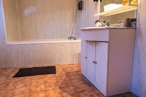 a bathroom with a sink and a bath tub at Le Saint-Cyr Issoudun - Cosy, Spacious & Downtown in Issoudun