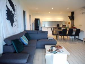 un salon avec un canapé bleu et une cuisine dans l'établissement Cap CORSE URIBELLINU 2, à Santa-Maria-di-Lota