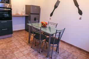 a kitchen with a table with chairs and a fork on the wall at Le Saint-Cyr Issoudun - Cosy, Spacious & Downtown in Issoudun +1 photo