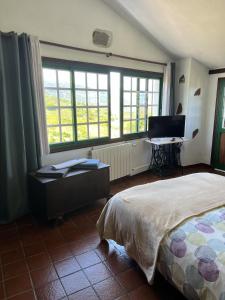 um quarto com uma cama, uma secretária e janelas em Casa rural suerteluna em La Matanza de Acentejo