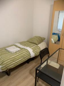 1 dormitorio con cama, espejo y mesa de cristal en Chambre privée avec partage des espaces communs en Créteil