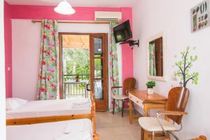 um quarto com uma cama, uma secretária e uma mesa em Joanna Apartments em Kontokali