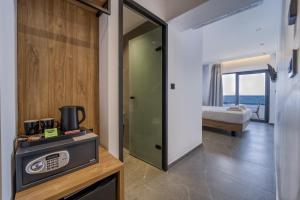 eine Küche mit einer Mikrowelle und ein Zimmer mit einem Bett in der Unterkunft Island Sea Side Hotel - Adults Only in Rhodos (Stadt)
