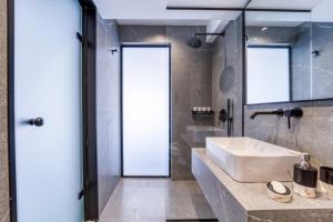 ein Badezimmer mit einem weißen Waschbecken und einem Spiegel in der Unterkunft Island Sea Side Hotel - Adults Only in Rhodos (Stadt)