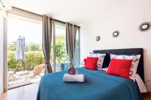 1 dormitorio con cama azul y almohadas rojas en Cassis, Appartement 3 chambres avec terrasse, en Cassis