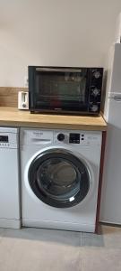 um micro-ondas sentado em cima de uma máquina de lavar roupa em Le Repos du Randonneur em Audinghen