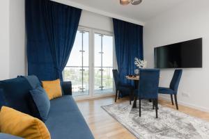 sala de estar con sofá azul y mesa en Business Apartments Kasprzaka with Parking by Renters, en Varsovia