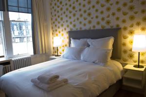 
a white bed with a white comforter and pillows at Grasshopper Hotel Glasgow in Glasgow
