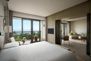 1 dormitorio con 1 cama y sala de estar en Sanya Marriott Yalong Bay Resort & Spa en Sanya