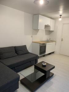 a living room with a couch and a table at Chambre privée avec partage des espaces communs in Créteil