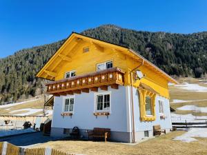 ein kleines Haus mit gelbem Dach auf einem Feld in der Unterkunft Bergluft Appartement - Haus Lerchegger in Mössna