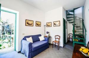 sala de estar con sofá azul y escalera en Casa Tiberio, en Massa Lubrense