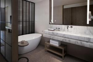 a bathroom with a tub and a sink and a mirror at Sanya Marriott Yalong Bay Resort & Spa in Sanya
