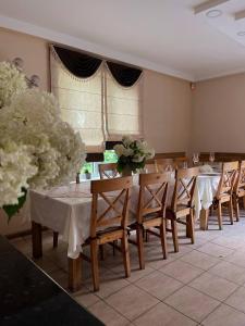 une salle à manger avec des tables, des chaises et des fleurs dans l'établissement Zeltini, à Riga