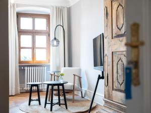 a living room with a table and a tv at Gästehaus Schloss Janson 