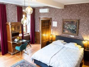 a bedroom with a large bed and a table and a desk at Gästehaus Schloss Janson 