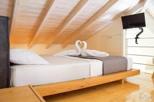 ein Schlafzimmer mit zwei Schwänen auf einem Bett in der Unterkunft Mare Loft in Kalamata