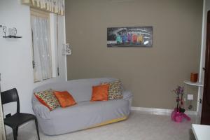 sala de estar con sofá gris y almohadas de color naranja en i picciotti, en Erice