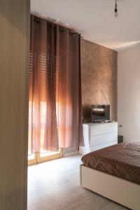 a bedroom with a bed and a tv and a window at Monfalcone City Room Rental Apartment in Cagliari
