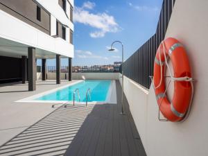una piscina al lado de un edificio en Apartment Abora with Pool, Gym and Free Parking, en Las Palmas de Gran Canaria