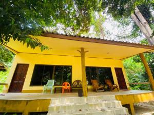 a yellow house with a cross on the front of it at Banana Resort in Ko Phayam